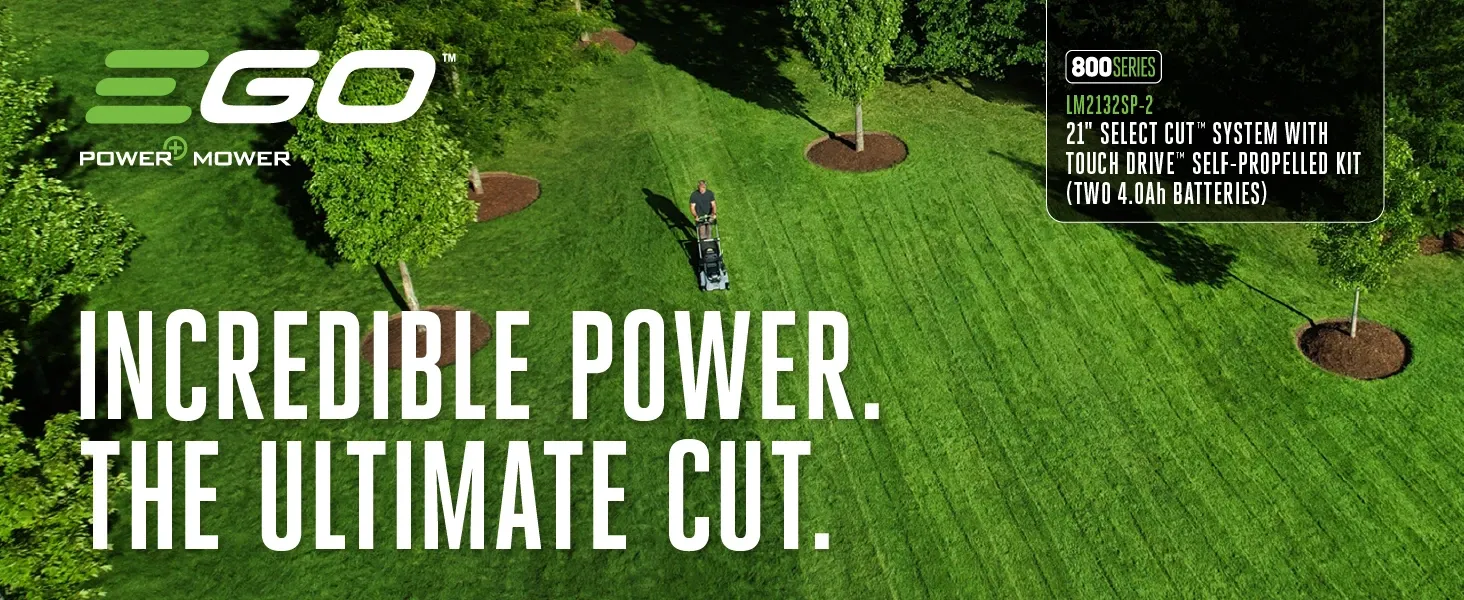 Aerial view of a man using an EGO Power+ lawn mower on a large, neatly cut green lawn with trees and landscaping.